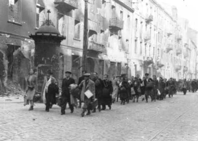 Jews rounded up during the Warsaw ghetto uprising are forced to march to the assembly point for deportation